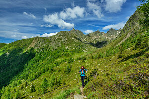  Woman hiking on the Pfunderer Höhenweg ascends to the Kleines Tor, Pfunderer Höhenweg, Zillertal Alps, South Tyrol, Italy 