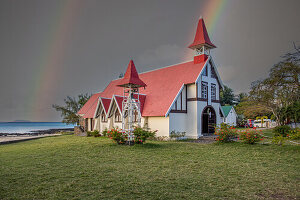  Notre-Dame Auxiliatrice de Cap Malheureux, church with red roof directly by the sea and Mauritius at sunset 