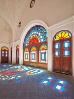  Zimmer mit bunten Buntglasfenstern im Tabatabaei-Haus, einem historischen Herrenhaus, das um 1880 in Kashan, Iran, erbaut wurde. 