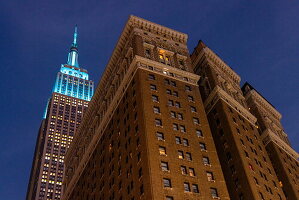 Beleuchtetes Empire State Building mit Backsteinhochhaus in Manhattan bei Nacht, New York, New York, USA, Nordamerika