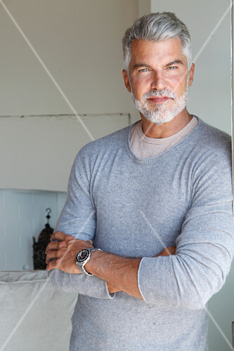 A Grey Haired Man Wearing A Light Grey Jumper Over An Under