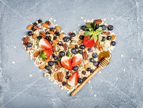 Ingredients for healthy breakfast: muesli in shape of heart