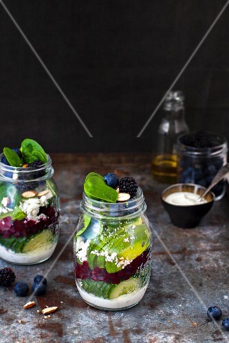 Vegetable salads with berries and yoghurt dressing in glass jars