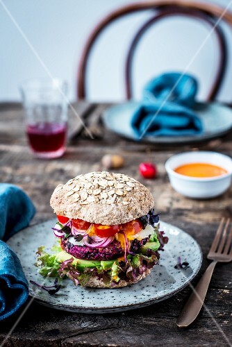 A veggie burger with wholegrain bread, lentils, avocado, sheep's cheese and tomatoes