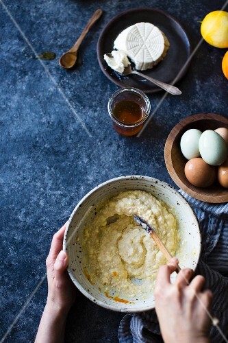 A chef stiring ingredients in a mixing bowl